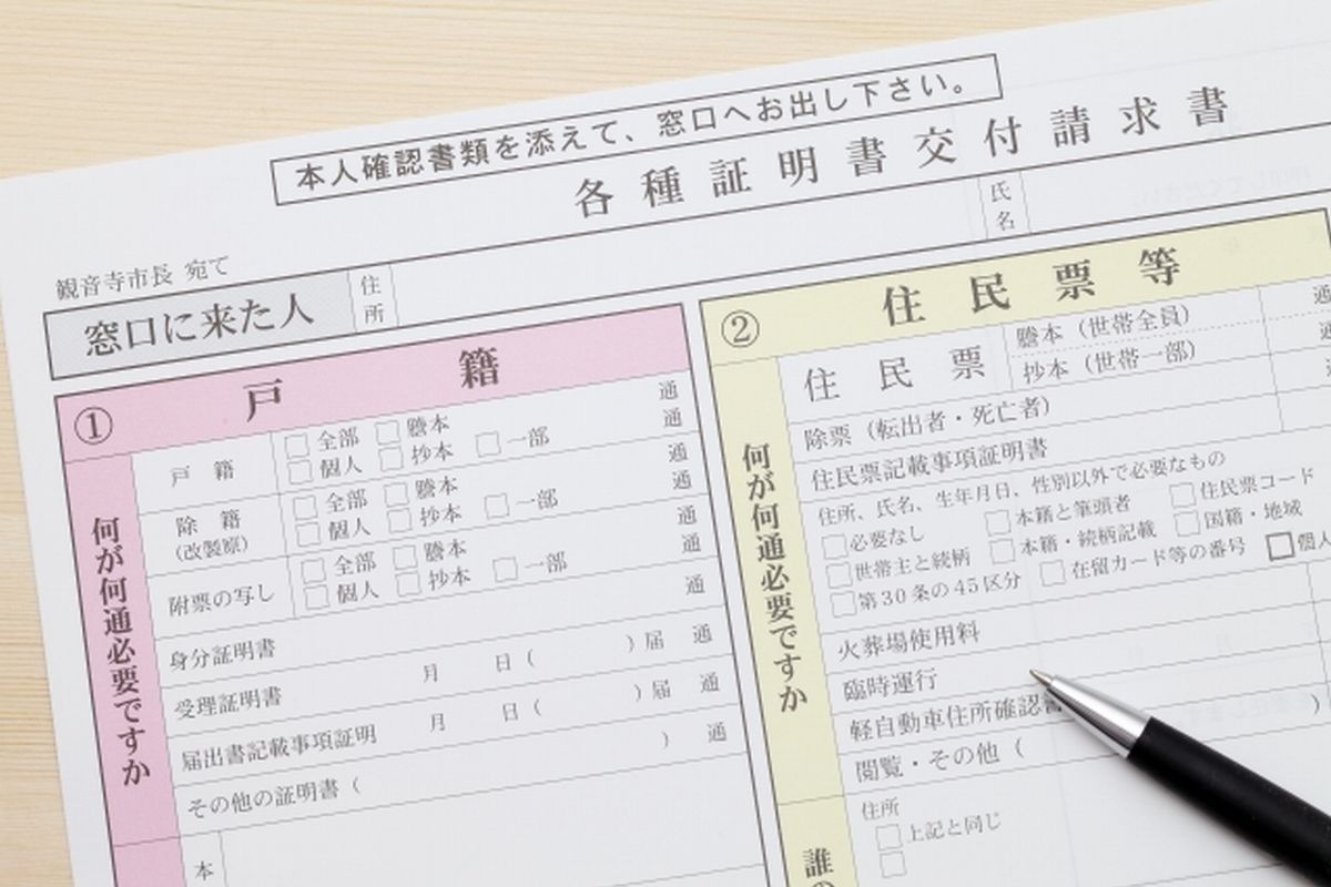 机の上に置かれた各種証明書交付請求書とペンの写真。戸籍や住民票など行政手続きに関するイメージ。