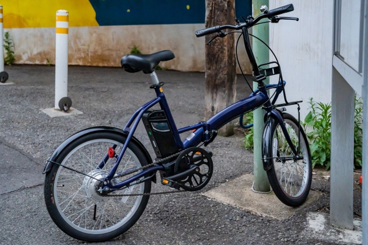 都市の道端に止められた折り畳み式電動自転車の画像。シニアでも気軽に始められる自転車習慣を象徴するイメージ。