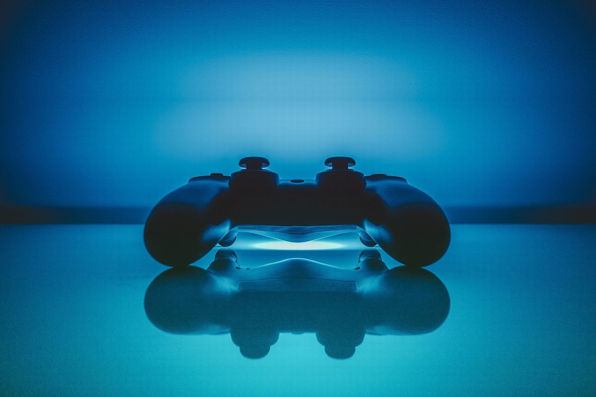 ゲームコントローラーを手にする高齢者のイメージ。ゲームは脳や心の活性化に効果的