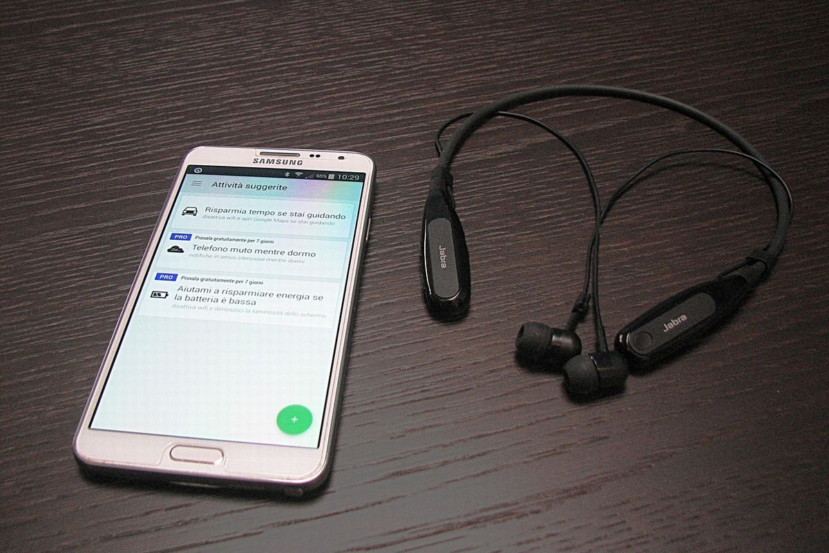 黒い机に置かれたスマホとイヤホン｜オンラインでつながる孤独対策イメージ